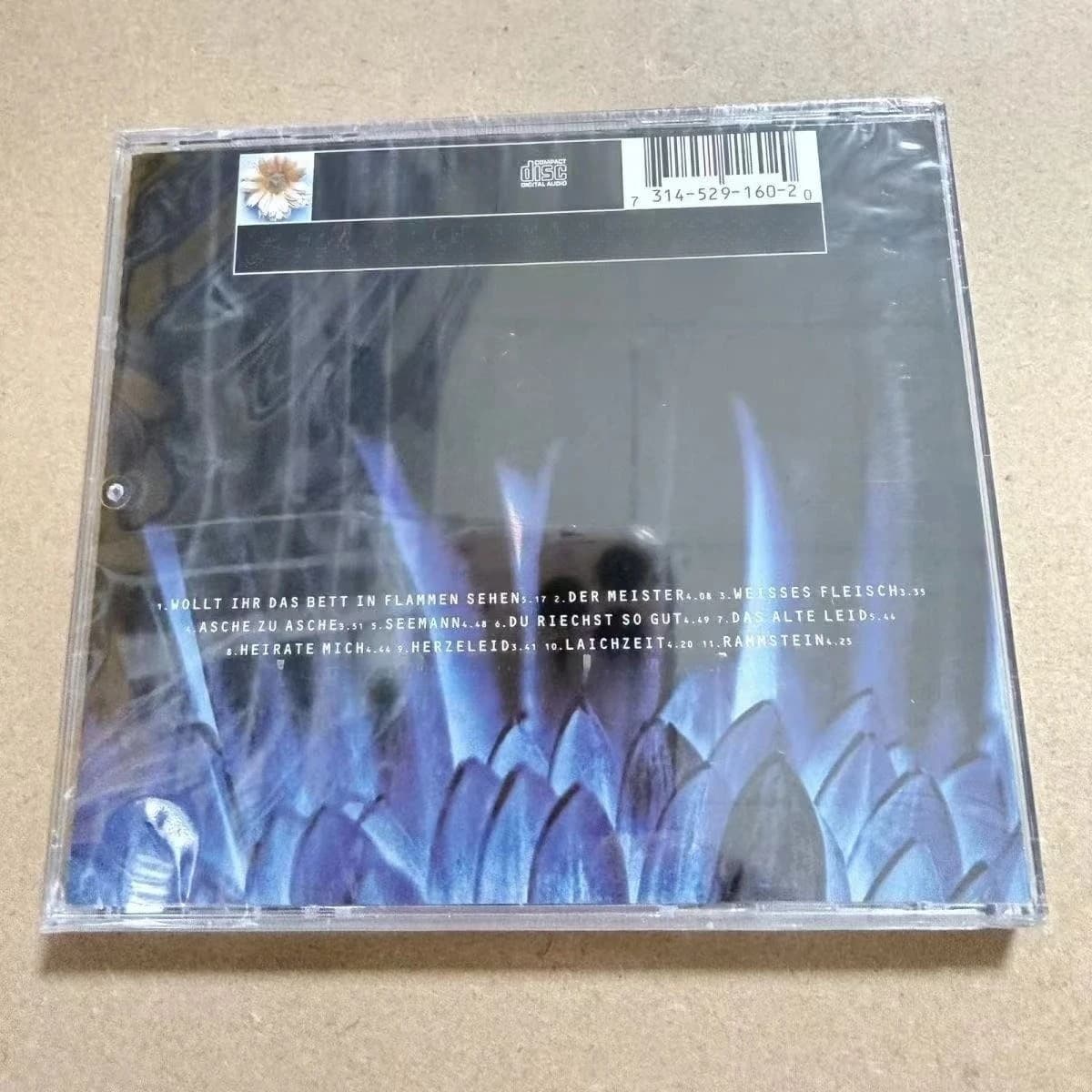 Disque CD audio industriel allemand en métal, portrait d'une formation musicale à six membres aux tons froids sur fond pâle, disque de collection Heavy Rock